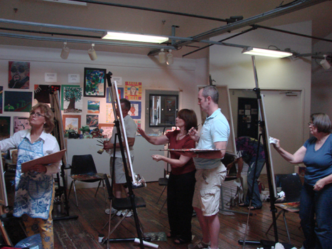 Luana instructing a student at their easel.